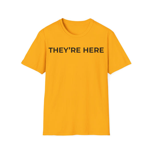 They’re Here t-shirt design, featuring bold white uppercase typography reading “THEY’RE HERE” in a clean minimalist text based layout on a gold yellow background