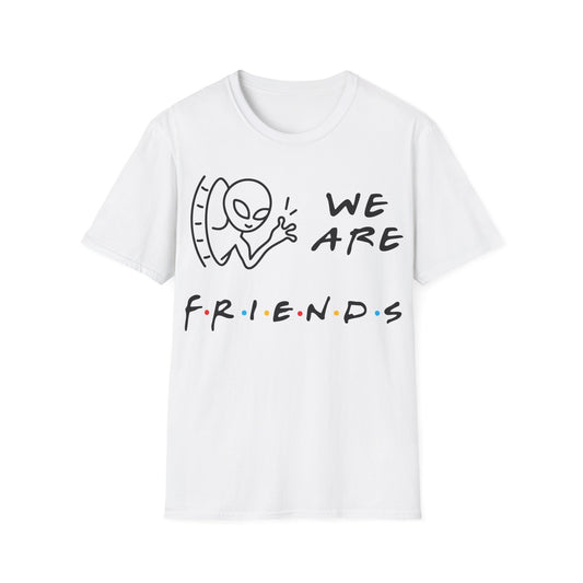 We Are Friends t-shirt design, featuring a smiling alien waving through a doorway beside playful handwritten lettering with colorful dot accents on a white background
