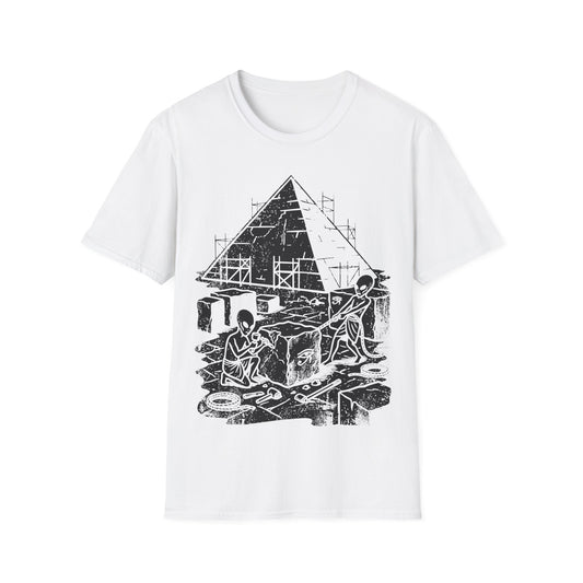 Aliens Building Giza t-shirt design, featuring two grey aliens carving and hauling stone blocks in front of a partially constructed Egyptian pyramid with scaffolding and Eye of Horus symbols in a black and white illustration on a white background